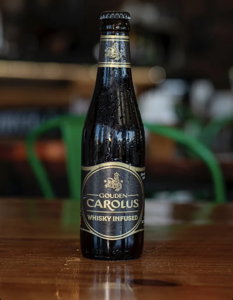 Botella de Gouden Carolus Whisky Infused sobre la mesa