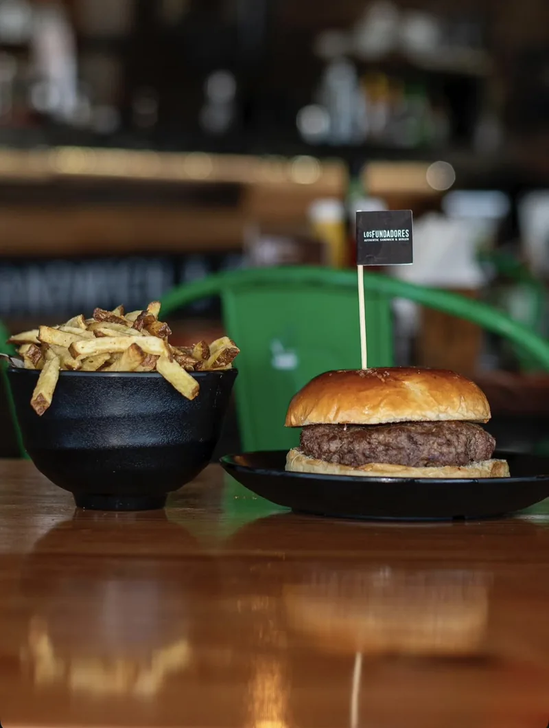 Fundador Jr., burger de 200 gr, junto a un bowl de papas fritas